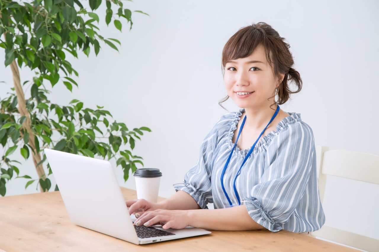 目はこちらを見ながらキーボードを打っている女性