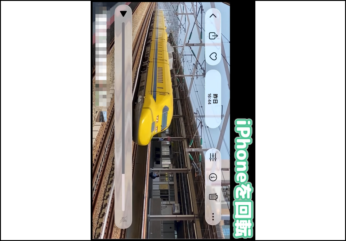 iPhoneの写真アプリで横向き動画を一時停止し、再生バーや「iPhoneを回転」のテキストが表示されている画面